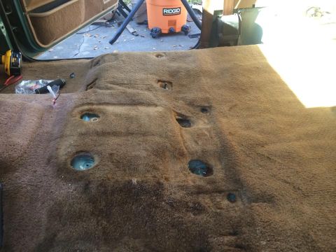 1990 Ford Bronco - The interior carpet has been removed from the vehicle, revealing the floor pan underneath.