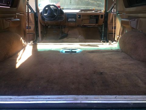 1990 Ford Bronco - The interior of the vehicle is shown with the carpet removed from the rear cargo area.