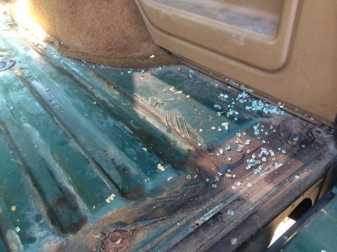 1990 Ford Bronco - The interior floor of the vehicle shows evidence of broken glass and wear.