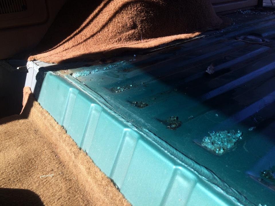 Interior cargo area floor with brown carpet and teal plastic trim