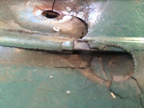 1990 Ford Bronco - Close-up of rusted metal panel showing damage and a central hole.