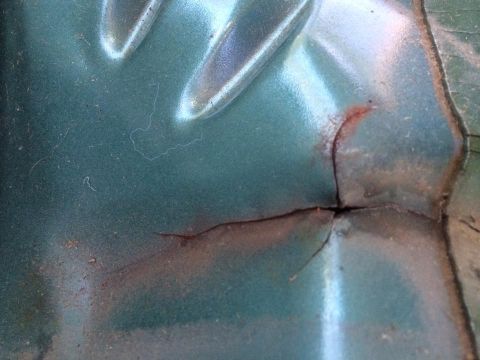 1990 Ford Bronco - This image shows a damaged section of a vehicle's body, revealing rust beneath the paint.