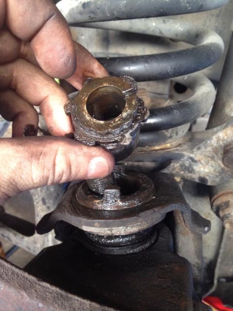 1990 Ford Bronco - Removing a ball joint nut from suspension components.