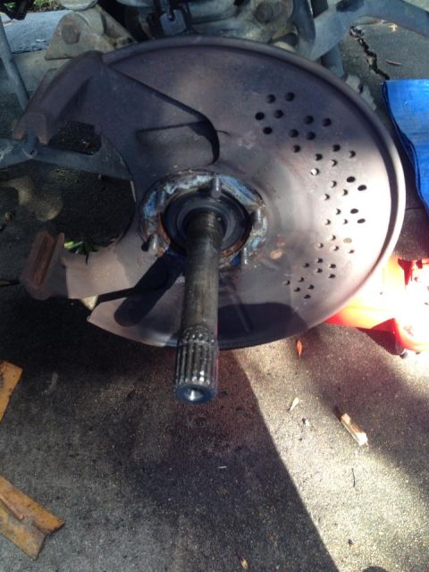 1990 Ford Bronco - A damaged brake rotor and axle assembly is shown, with visible wear and tear.