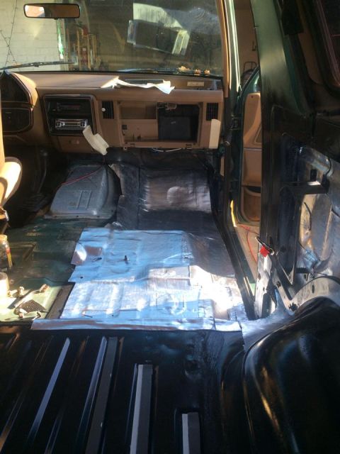 1990 Ford Bronco - The interior of a 1990 Ford Bronco is shown with sound deadening and insulation being installed on the floor.