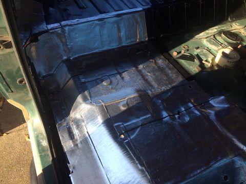 1990 Ford Bronco - Sound deadening material is being applied to the floor of a vehicle's interior.