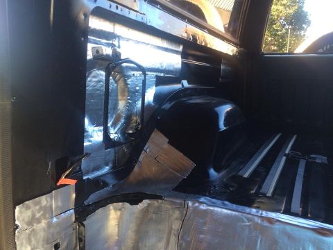 1990 Ford Bronco - The interior of a vehicle shows sound deadening material being applied to the floor and rear panels.