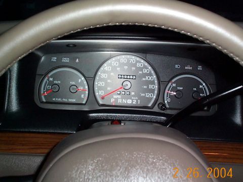 2003 Ford Crown Victoria - The interior of a vehicle shows the dashboard gauges, including the speedometer, fuel, volts, and temperature readings.