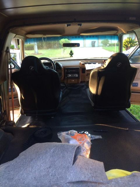 1990 Ford Bronco - The interior of a 1990 Ford Bronco shows black seats and a tan dashboard.