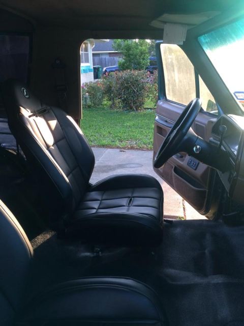 1990 Ford Bronco - The interior of a 1990 Ford Bronco features black bucket seats and a view of the steering wheel and dashboard.