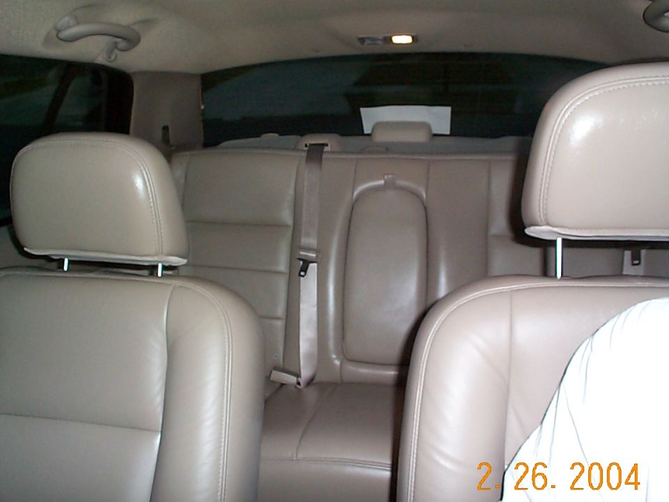 Tan leather sedan interior viewed from the front seats toward the rear bench