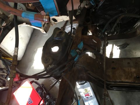 1987 Ford Bronco - Close-up view of engine bay components, including hoses and metal brackets, during a rebuild.