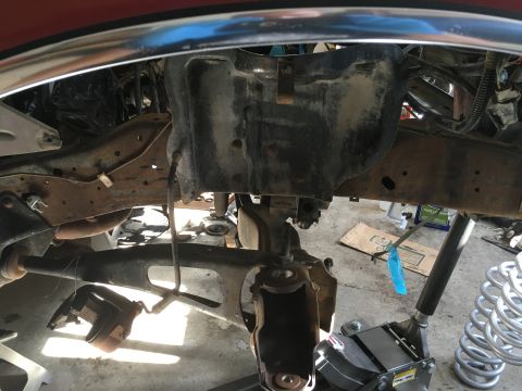 1987 Ford Bronco - The underside of a vehicle is shown with suspension parts removed, indicating ongoing maintenance or repair work.