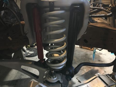 1987 Ford Bronco - Close-up view of a vehicle's front suspension system, prominent coil springs and shock absorbers.