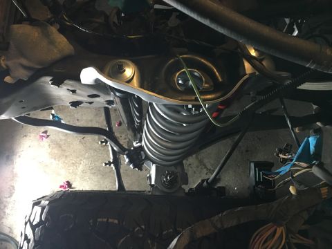 1987 Ford Bronco - Close-up view of vehicle suspension and engine bay components during a rebuild.