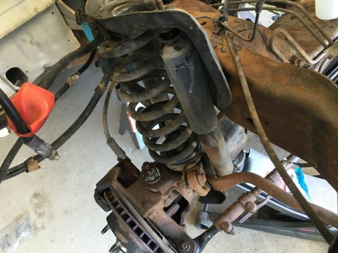 1987 Ford Bronco - This image shows the front suspension and braking system of a vehicle, likely undergoing maintenance or repair.