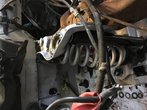 1987 Ford Bronco - Close-up view of suspension components within a vehicle's engine bay, showing springs and metalwork.