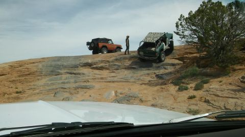1979 Ford Bronco - Two off-road vehicles navigate a challenging rocky landscape under a cloudy sky.