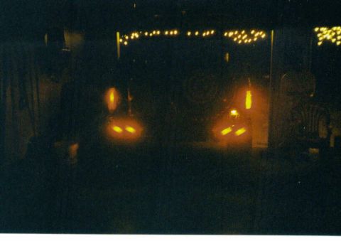 1988 Ford Bronco - Two vehicles are visible at night, with their headlights and taillights illuminated, creating an abstract scene.