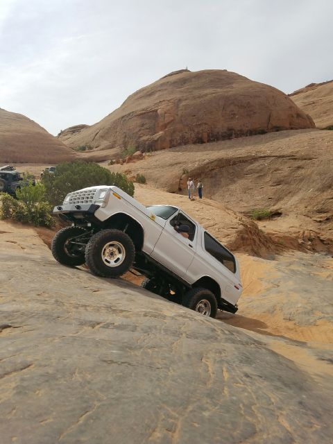 1979 Ford Bronco - This modified SUV navigates a steep, rocky trail in a desert landscape.