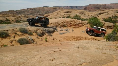 1979 Ford Bronco - Two classic Ford Broncos tackle a challenging off-road course in a desert canyon.