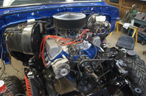 1979 Ford Bronco - The engine compartment of a vehicle is shown with its V8 engine and various components.