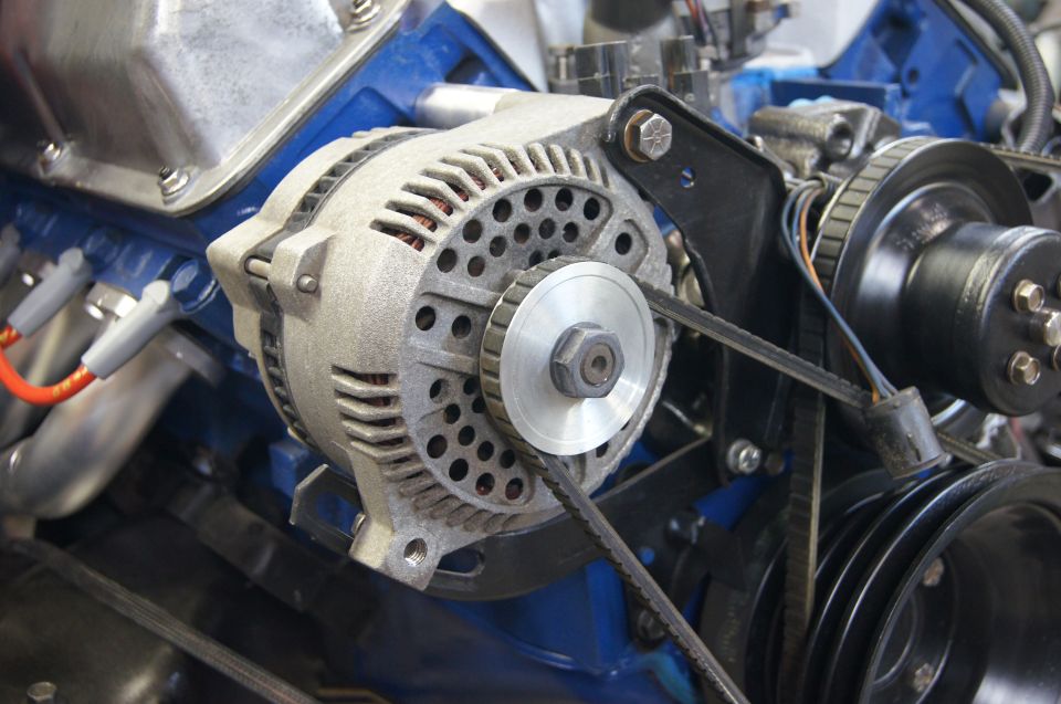 Alternator and pulleys on a blue engine block