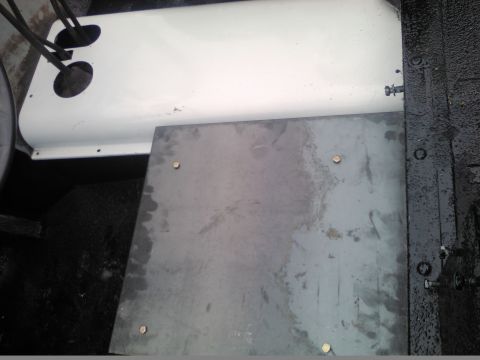 1991 Ford Bronco - Close-up view of the interior floor panel, showing a metal plate and a white component with electrical conduits.