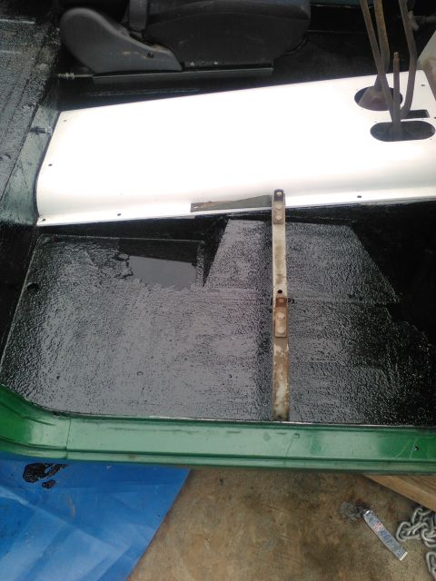 1991 Ford Bronco - Vehicle interior floor showing black coating and a white door sill.