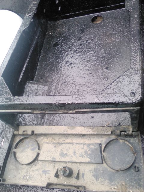 1991 Ford Bronco - The battery tray shows signs of wear and tear, with dirt and moisture present.