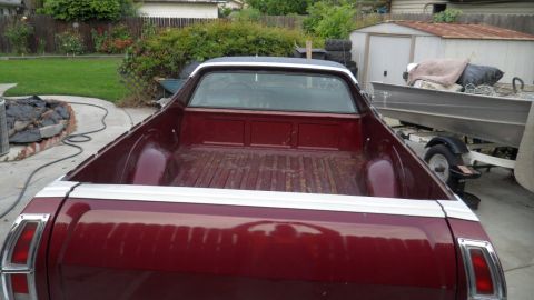 1972 Ford Ranchero - Rear view of a maroon pickup truck with a white stripe on the tailgate, parked in a driveway.