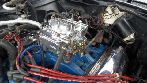 1972 Ford Ranchero - Close-up of a vehicle's engine bay, a prominent chrome Holley carburetor and bright blue engine block.