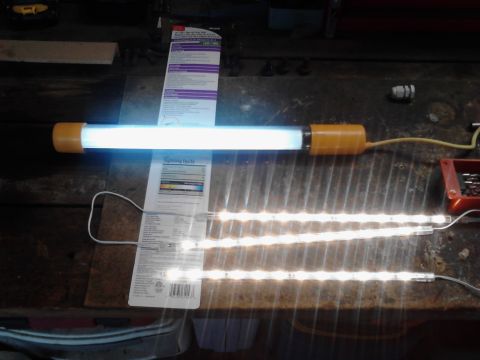 1990 Ford Bronco - A fluorescent light fixture and LED strips are laid out on a workbench, with packaging visible.