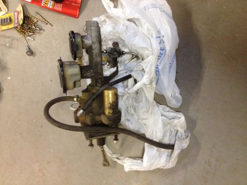 1973 Ford Bronco - A brake booster and master cylinder assembly is shown, partially wrapped in plastic.