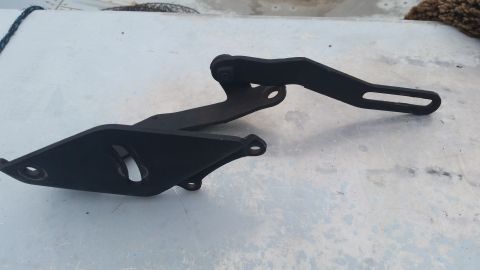 1981 Ford Bronco - A black metal engine bracket is shown against a light-colored surface.