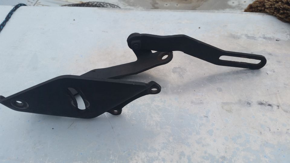Black metal engine bracket with two mounting holes and an adjustable arm