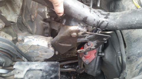 1981 Ford Bronco - Close-up view of engine components, including hoses and brackets, with a red part visible.