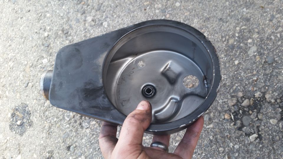 Hand holding an open air cleaner housing with a metal filter base