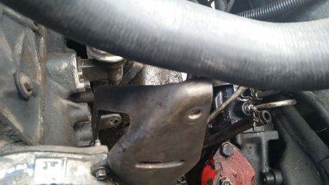 1981 Ford Bronco - Close-up of engine components, including a metal bracket and hose, with visible Supermotors.net watermark.