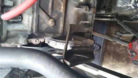 1981 Ford Bronco - Engine and transmission components shown in detail, with hoses and a metal bracket visible.