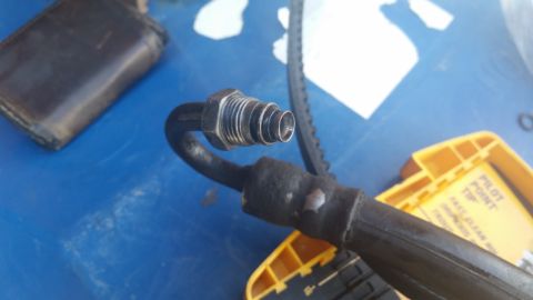 1981 Ford Bronco - A close-up view of a metal hose fitting, likely part of a vehicle's fluid system.
