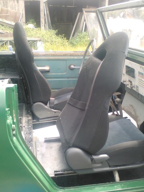 1991 Ford Bronco - Interior view of a green vehicle showing aftermarket bucket seats and dashboard details.
