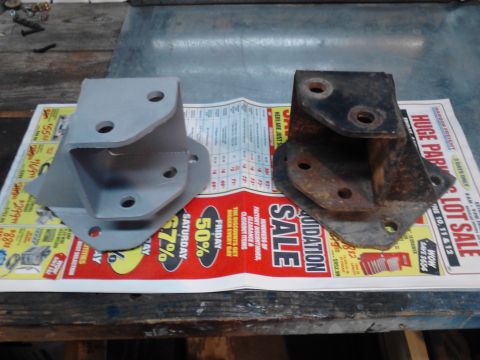 1990 Ford Bronco - Two metal brackets, one new and one old, are displayed on a newspaper advertising a liquidation sale.