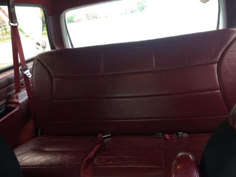 1995 Ford Bronco - Interior view of a maroon rear bench seat with red seatbelts.