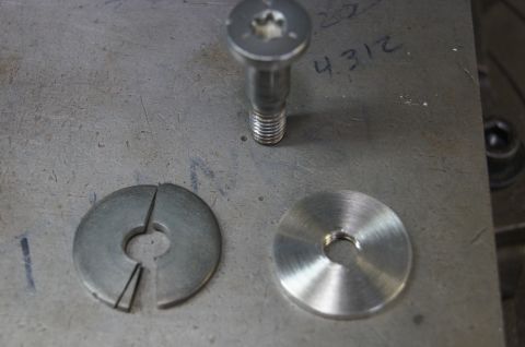 1979 Ford Bronco - A bolt and two washers, one of which is split, are shown on a metal surface. Handwritten numbers are visible in the background.