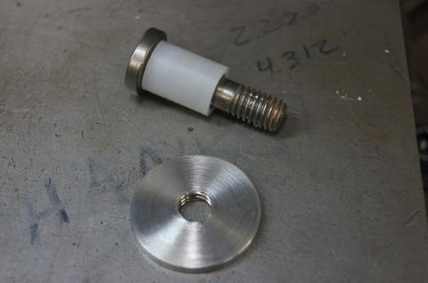 1979 Ford Bronco - Close-up of a bolt, spacer, and washer on a workbench surface.