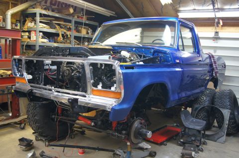 1979 Ford Bronco - A blue 1979 Ford Bronco is shown in a garage with its front end removed for restoration work.