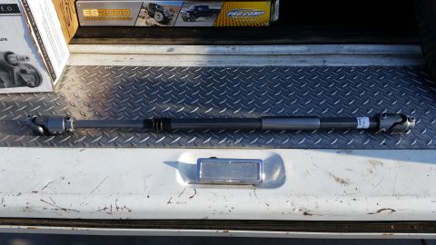 1992 Ford Bronco - A steering shaft is shown resting on a diamond plate surface, with boxes in the background.