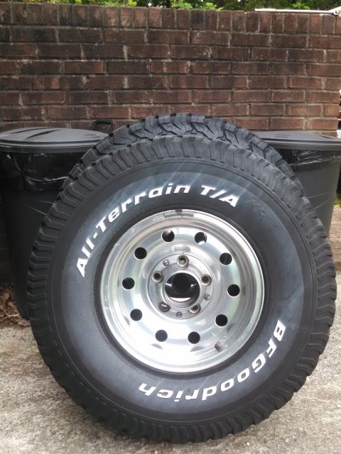 1995 Ford Bronco - BFGoodrich All-Terrain T/A tire and aluminum wheel shown against a brick wall and trash cans.