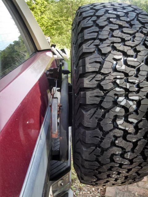 1995 Ford Bronco - Side view of a red SUV showing a spare tire mounted externally on the rear.